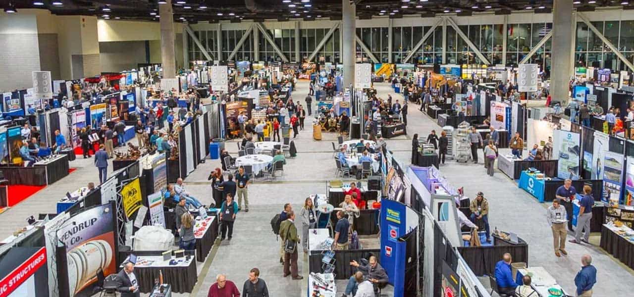 AEMA-Annual-Meeting Large indoor trade show at the Annual Meeting, featuring numerous booths and displays, with attendees engaging and networking throughout the Nevada MPD convention center.
