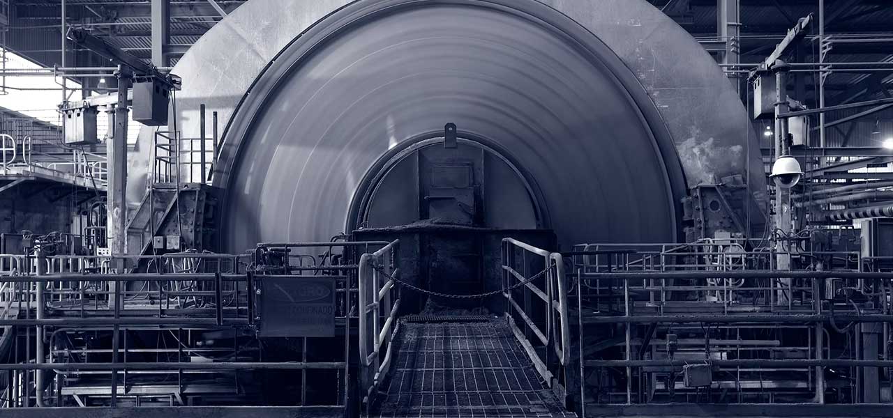 Large industrial rotary drum machine surrounded by metal walkways and equipment in a factory setting, showcased during the Nevada MPD Annual Meeting.